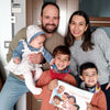  Una familia feliz de 5 personas sostiene su libro familiar personalizado, que es un excelente regalo para el Día del Padre.