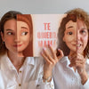 Hermosa madre y su hija mostrando su libro de Hooray Heroes con personajes personalizados en la portada.